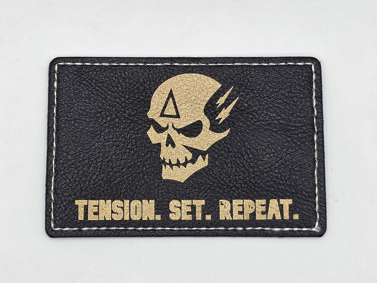 Black and gold patch: Tension. Set. Repeat.